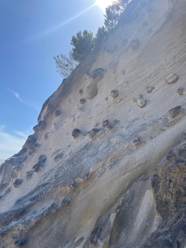 Weird rock formations on a sandy cliff face. Looks like man made rock climbing holds but it is natural.
